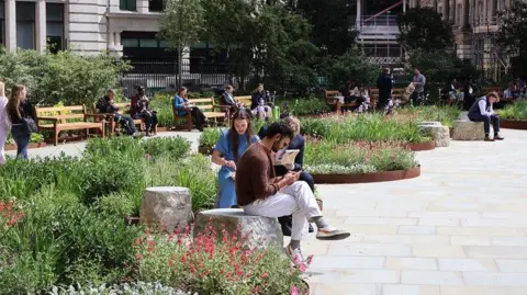 People sit on seating in the newly opened Finsbury Circus Gardens