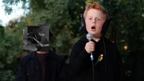 Ginger boy holds a microphone