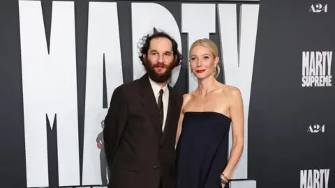 Josh Safdie and Gwyneth Paltrow posing together at the Marty Supreme premiere