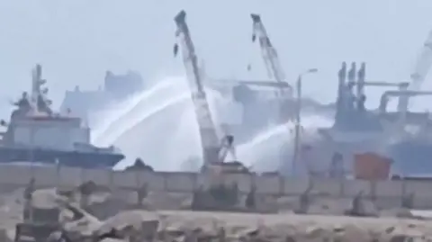 Social media video shows tugboats firing water jets at vessels on fire in Damietta port, Egypt (29 July 2026)
