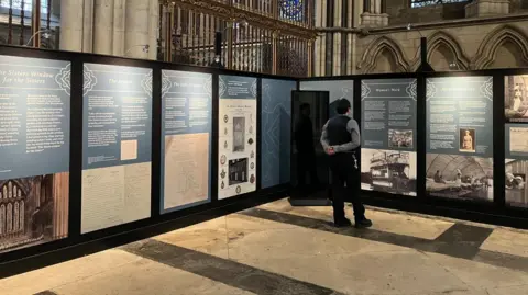 Man looking at exhibition display boards in York Minster
