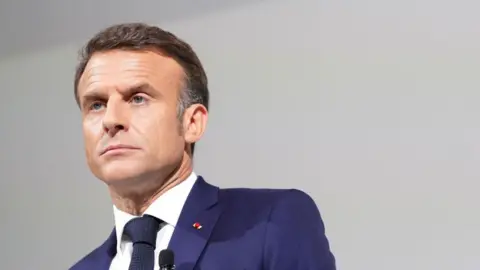 Getty Images French President Emmanuel Macron wearing a blue suit with a stern look on his face