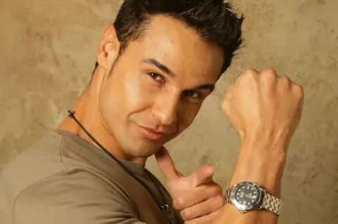 Getty Images Chico Slimani poses for a portrait to celebrate of his debut single. He wears a watch and points at the camera 