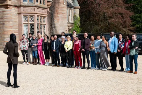 BBC/Studio Lambert Claudia stands in front of series three's contestants. They are all standing in front of the castle.