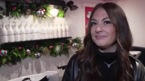 Sam O'Neil looking at the camera has dark eyes and hair, and is wearing a black top.