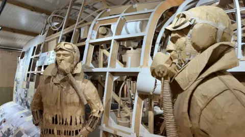 RAF Ingham Heritage Centre Models of airmen standing next to a model bomber fuselage