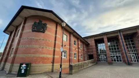 The front entrance to a large brick building with the words Crown Court, County Court in silver lettering on the wall