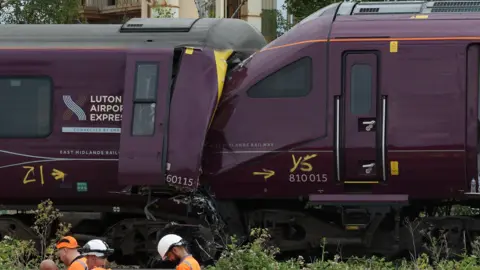The ends of two damaged purple trains which have crashed together. 
