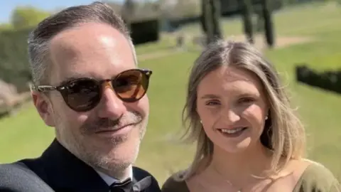 Handout Young man and woman smiling outdoors to camera