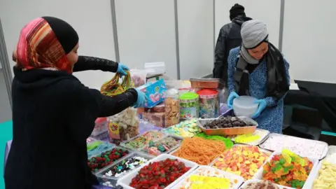 Women prepare food during the 35th annual meeting of the French Muslim community on March 30, 2018 at Le Bourget, north of Paris.