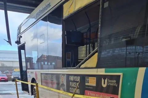 Stagecoach A Stagecoach bus with one of the main windows smashed. It is parked and the door is open.