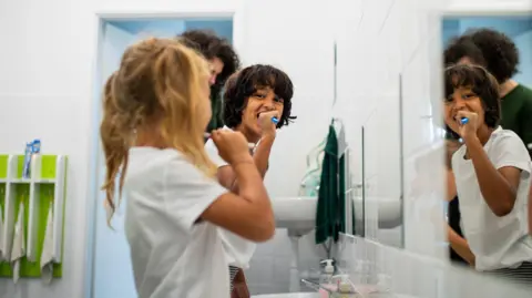 Getty Images Small children brushing teeth in a bathroom