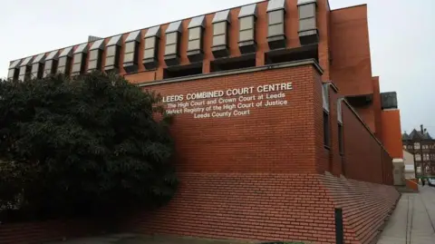 Leeds Crown Court, a red brick building with the words "Leeds Combined Court Centre" on a wall