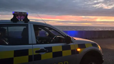 HM Coastguard Fleetwood Coastguard car above the beach with sunset in background