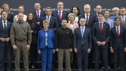 World EPA leaders pose for a photo.  In the center is Zelenksy, behind is von der Leyen.  Sunak, Trudeau and Kamala Harris were also in the crowd