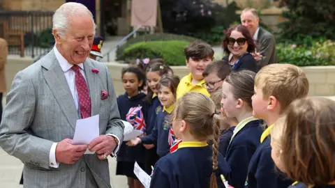 Reuters Pupils from Willow Lane Primary School lined up meeting a smiling King Charles
