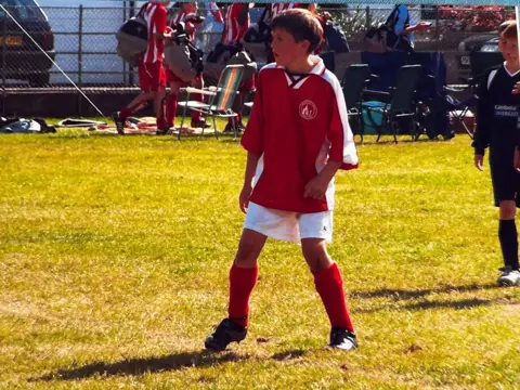 Souttar family A young boy plays football wearing a red football strip