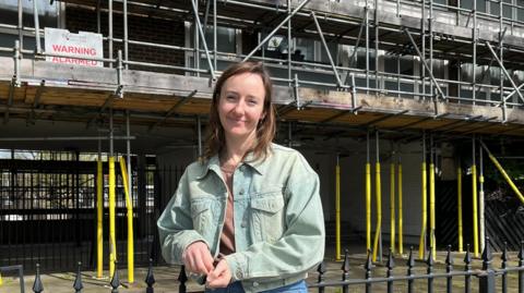 Sarah Barraclough standing in front of the scaffolding