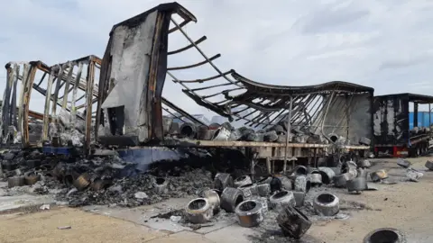 The wreckage of the trailers destroyed in the fire