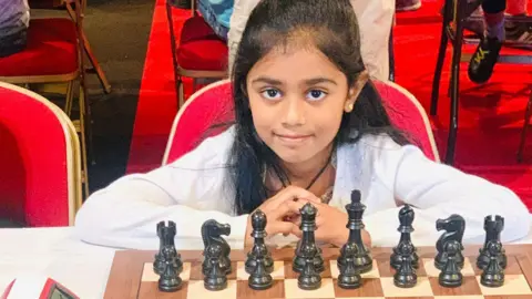 Shalini Sathiyaseelan Tara behind a chess board