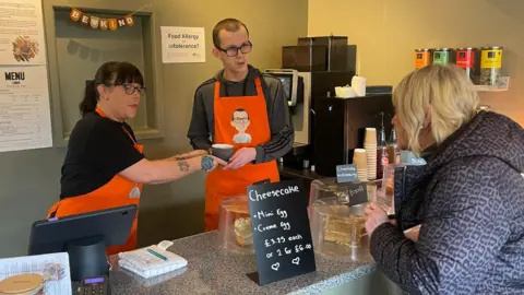 Loui and his mother Emily serving a customer