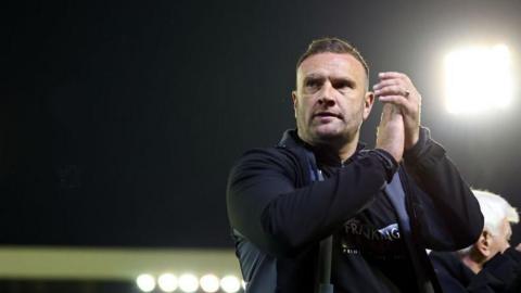 Ian Evatt the head coach / manager of Bolton Wanderers applauds the fans at full time during the Sky Bet League One Play-Off Semi Final 1st Leg match between Barnsley and Bolton Wanderers at Oakwell Stadium on May 3, 2024 in Barnsley, England