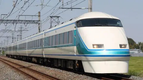 A train travelling on tracks across a field