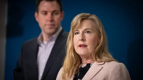 Melissa Hortman speaking with a man in the background