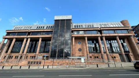 Newcastle Crown Court - a large building with red brick walls and columns and large dark windows