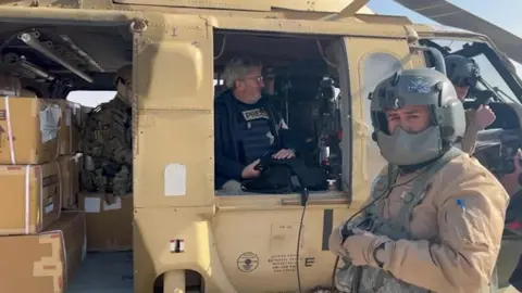 BBC The BBC's Fergal Keane sits on board a Jordanian helicopter filled with aid for Palestinians in Gaza, before it leaves an airbase in Jordan (28 January 2025)