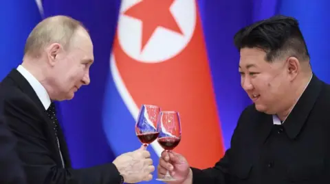 Getty Images Russian President Vladimir Putin and North Korean leader Kim Jong Un toast during a reception at the Mongnangwan Reception House in Pyongyang