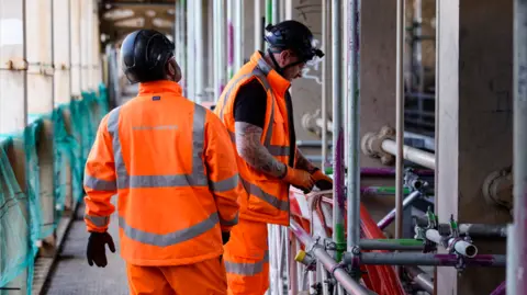 Network Rail Two people in hi-vis clothing making repairs to the bridge