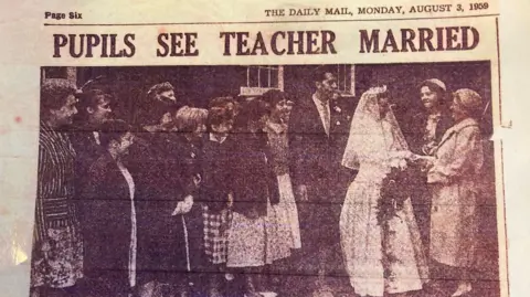 Hull Daily Mail A page from the Hull Daily Mail, dated 3 August 1959, showing a photo of a bridge in a white dress being congratulated by an older women, watched by the groom and a group of schoolgirls. The headline reads: "Pupils see teacher married".