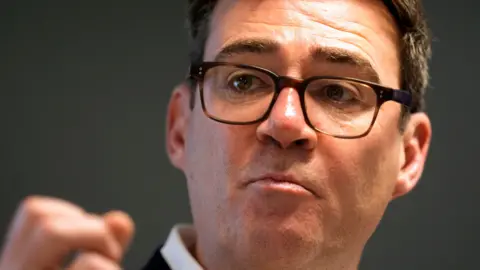 PA An up close shot of a man with pale skin, wearing dark brown tortoise glasses.