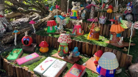 Shariqua Ahmed/BBC Colourful gnomes and other decorative items placed in the theme garden.