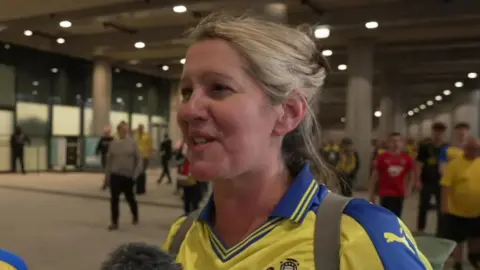 A woman and a boy wearing the Saints colours speaking to a reporter after the game at Wembley.