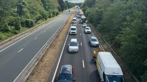 Queuing traffic on A38. Lots of car and lorries as road is closed