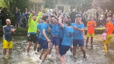 People playing football in the "ankle deep" water of a river