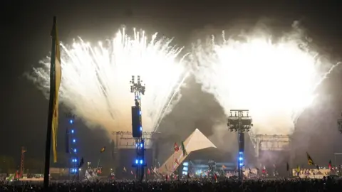 PA Media Fireworks coming from either side of the Pyramid Stage at night time after Dua Lipa performed during Glastonbury Festival at Worthy Farm in Somerset.