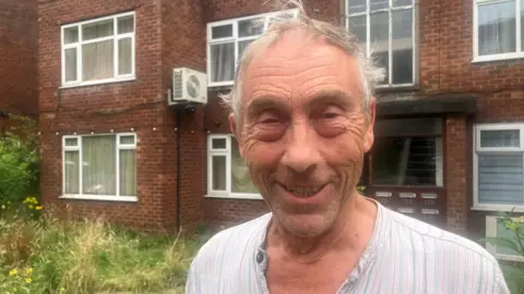 Photo of landlord David Adams in front of flats