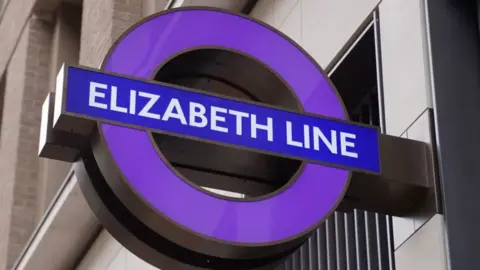 An Elizabeth line roundel sign outside Tottenham Court Road tube station in central London