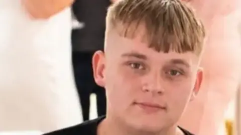 Kyeron Wheeler, a young man with blonde hair and a black T-shirt, looking at the camera.