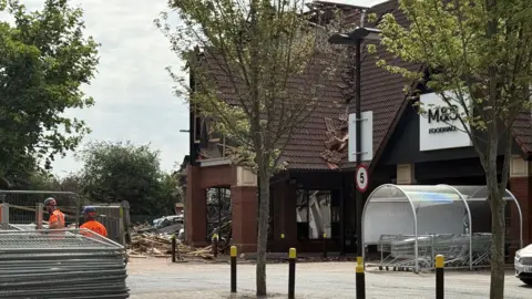 A picture of the front of Marks and Spencer foodhall with part of the building looking damaged 