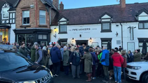 Rod Willis People stood outside the Pipemakers Arms