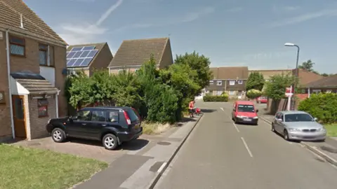 Google A screenshot from Google street view showing houses, cars and front lawns in Rochfords Gardens.