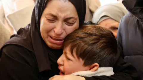 Reuters Taym al-Shayeb is comforted during the funeral of his father Ahmed, who was shot dead during an operation by Israeli security forces in Jenin, in the occupied West Bank (23 January 2025)