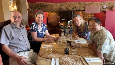 BBC The Pritchard family sit at a pub table