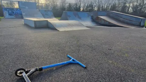 Surrey Heath Borough Council A skate park with a blue scooter lying on the concrete floor in front of it