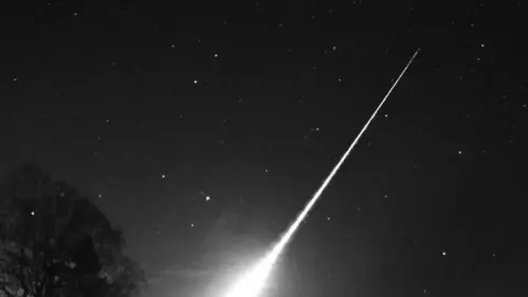 A photo of a bright meteor with a trail