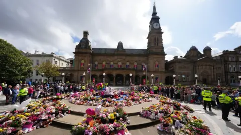 Floral tributes laid out in front of the Atkinson Building in Southport. Members of the public have gathered to pay their respects to the victims of the 29 July 2024 attack.